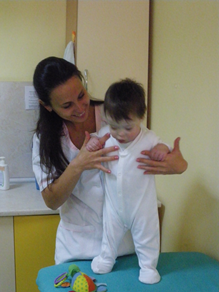 Petja, a physiotherapist, holding a child in a standing position